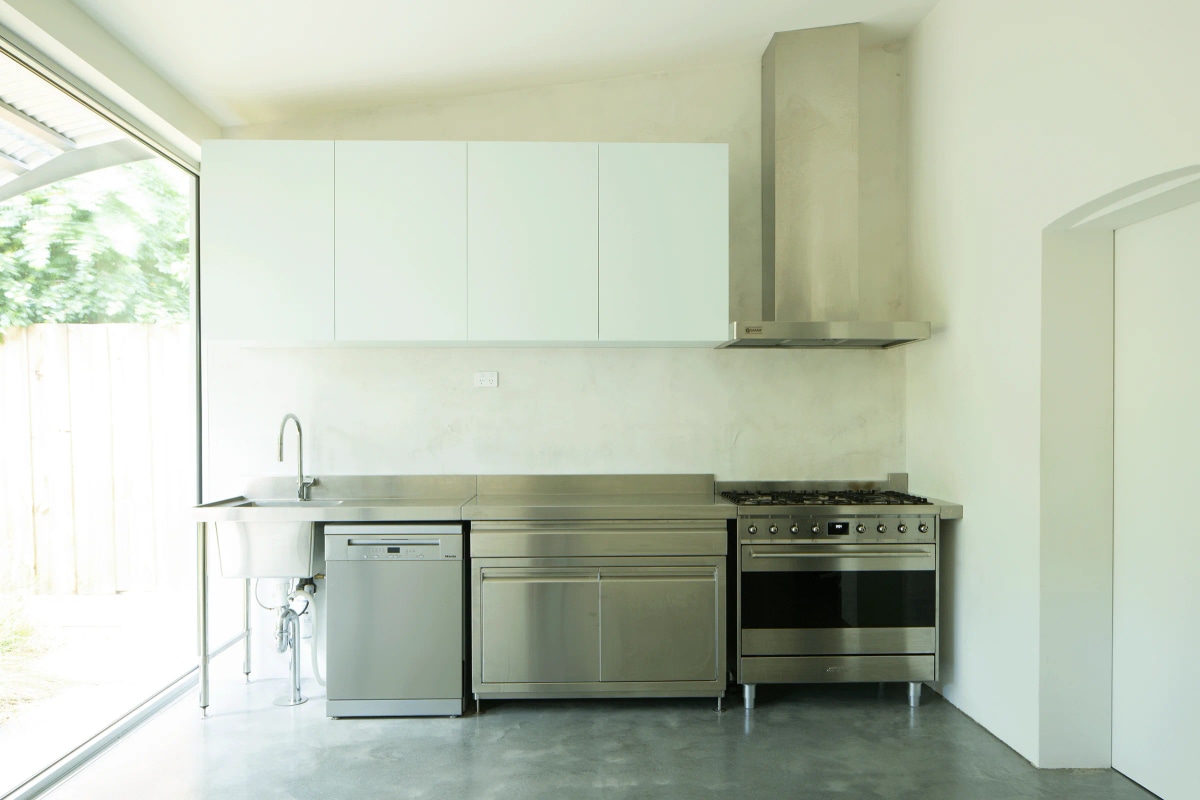 Stainless steel fast food kitchen at Economy House 1 by Office of Alexei Haddad